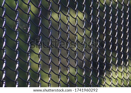 Close-up full frame view of a section of a black colored chainlink fence Royalty-Free Stock Photo #1741960292