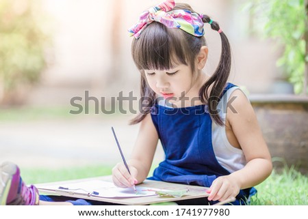 Close up background view Of cute girls drawing pictures for learning, artistic marketing concepts or studying during the semester outside the classroom