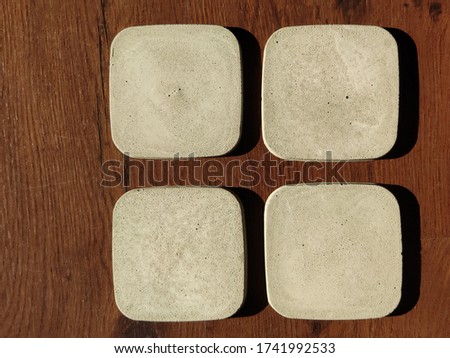 Square plates of cement, door cups, Oasters, concrete, on a wooden floor