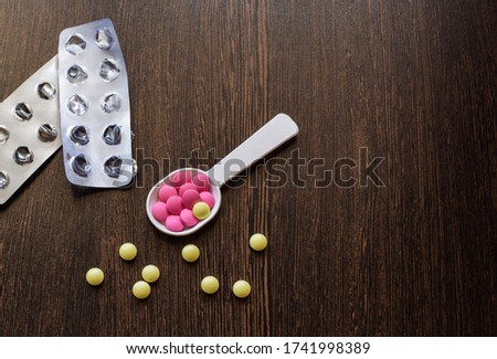 Colored pills on a dark background. Empty pack of pills. Place for text.