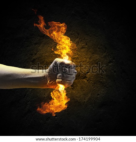 Close up of human hand holding fire flame