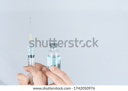 Closeup hand of woman doctor or scientist holding syringe and medicine liquid vaccine vial bottle. COVID 19 or coronavirus concept.