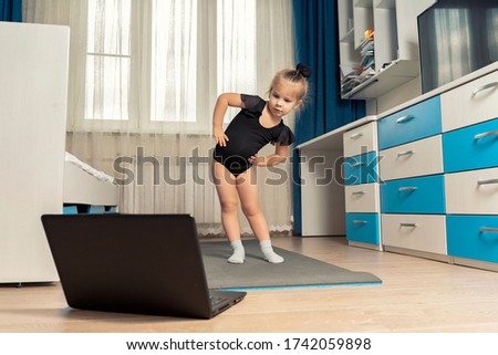 online rhythmic gymnastics. girl preschooler doing rhythmic gymnastics with a trainer online