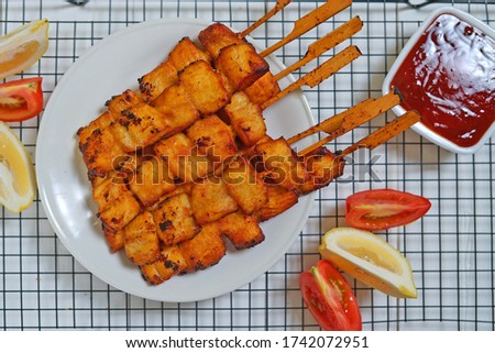 Fried fish on wooden skewers with sauce