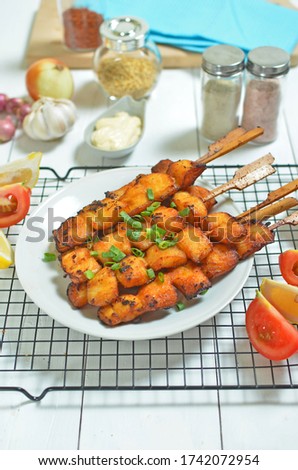 Fried fish on wooden skewers with sauce