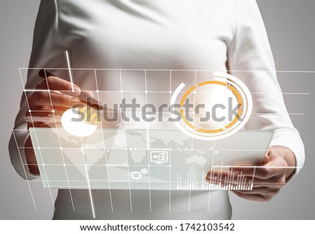 Businesswoman works with financial data. Futuristic interface with charts on virtual screen. Interactive financial diagrams and digital data visualization. Global e-business and internet investment.