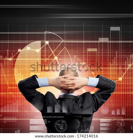 Back view image of businessman with arms crossed behind head
