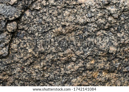 Textured surface of gray natural granite with cracks