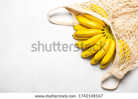 Organic rip of mini bananas in eco cotton shopper bag. Royalty-Free Stock Photo #1742148167