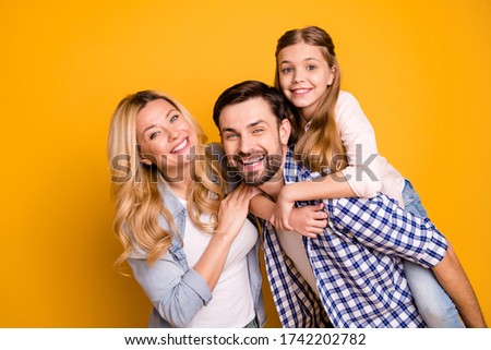 Photo wife beautiful mother lady husband dad guy couple carry little school girl daughter piggyback happy together play weekend wear casual clothes isolated yellow color background