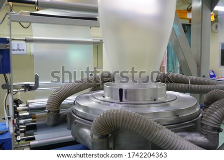 Extrusion blown film and slitting before rewinding to roll                            Royalty-Free Stock Photo #1742204363