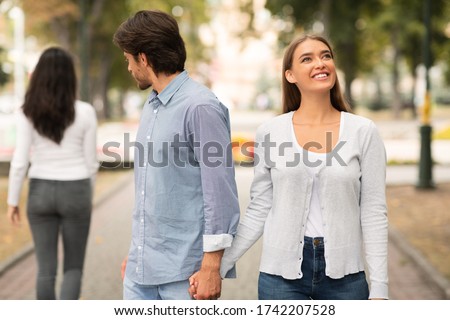 Lustful Cheating Boyfriend Looking At Other Woman Walking With Girlfriend In Park Outdoors. Selective Focus Royalty-Free Stock Photo #1742207528