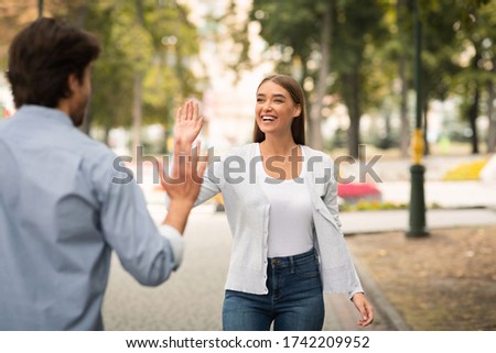 Hello Greeting. Girl Waving Hand Meeting Friend Guy Walking Outdoors In Park. Selective Focus Royalty-Free Stock Photo #1742209952