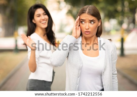 Toxic People. Girl Avoiding Meeting Tiresome Female Friend Pretending Not Noticing And Ignoring Greeting Walking Outdoors. Selective Focus Royalty-Free Stock Photo #1742212556
