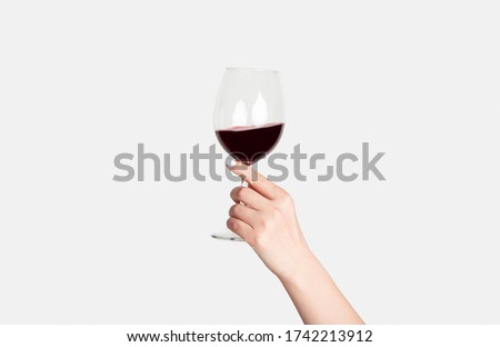 Young girl holding glass of tasty red wine on white background, close up