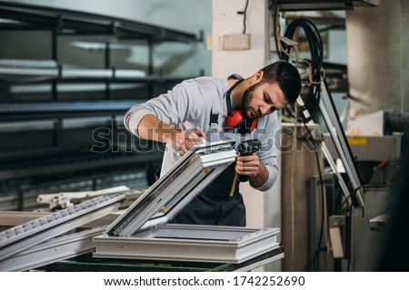 Aluminium and PVC industry worker making PVC or aluminium frames for windows and doors Royalty-Free Stock Photo #1742252690