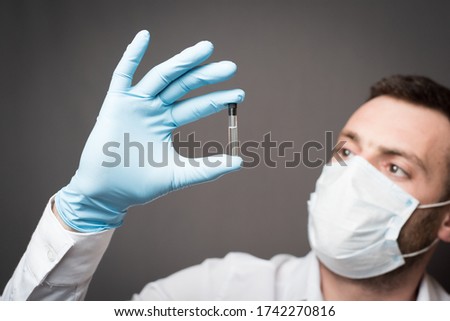 man in mask with an ampoule and a light bulb