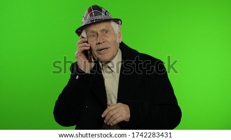 Elderly stylish grandfather caucasian mature man emotionally talking on mobile phone. Chroma key background. Old trendy grandparent in fashion clothes use smartphone. Technology for seniors people