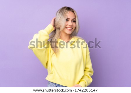 Teenager girl wearing a yellow sweatshirt over isolated purple background thinking an idea