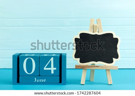 wooden calendar with the date of June 4 and an easel on a blue background, place for text,International Day of Innocent Children Victims of Aggression, World Caries Day