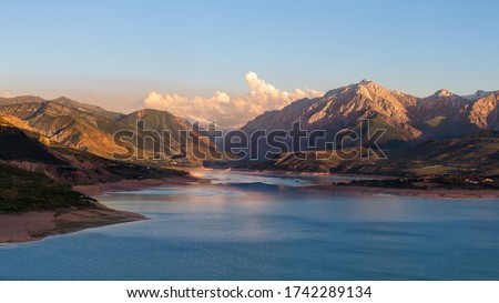 Beautiful mountain lake. Amazing mountain landscape with lake and sunset. Uzbekistan, Charvak Lake, 2020 Royalty-Free Stock Photo #1742289134