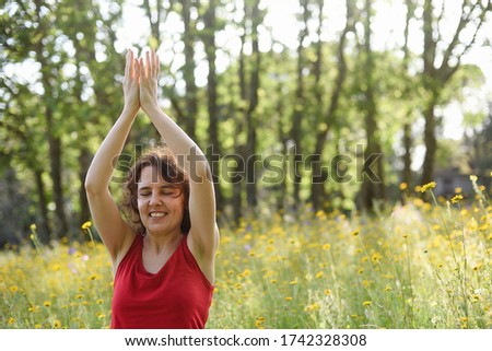 
Happy woman practicing yoga in the woods.