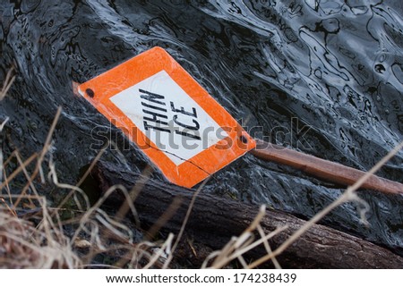 Thin Ice sign in water on lake
