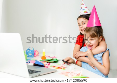 Kids online birthday party. Little girls in dresses, hat celebrate holiday with friends. Conference,video call in laptop, computer. Quarantine, coronavirus pandemic covid-19.