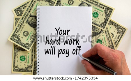 Male hand writing 'your hard work will pay off' on white note, on white background. Dollar bills.
