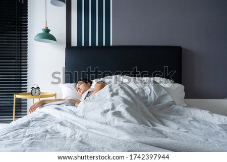 a girl sleeping next to an alarm clock. Time to wake up. On the wake-up clock 7 a.m. Deep sleep Royalty-Free Stock Photo #1742397944
