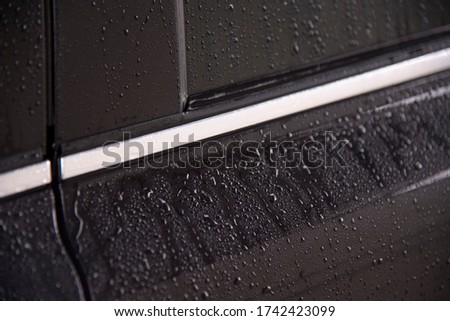 Part of the car covered in water as a background. car door and window close-up.