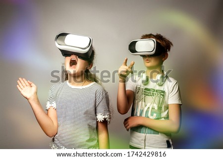 Portrait of boy and girl having fun with virtual reality headset. Emotional teenagers in virtual reality VR goggles. The concept of modern technologies and technologies of the future.