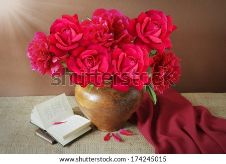 Still life with peony and roses bunch with book on artistic background