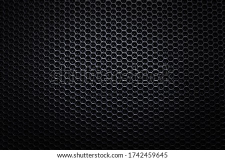 Abstract black metallic mesh texture for background with vignetting. Industrial backdrop. The speaker of a musical column. Design element. Close up. Copy space. 