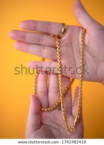 Women hand holding golden necklace. 