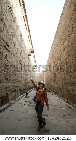 Asian tourist woman taking photo with Temple of Edfu interior Egypt Horus god landmark