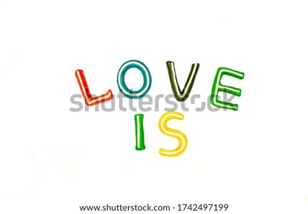two words LOVE and IS consists of plasticine letters of different colors on a white background. plasticine modeling preschool education, mockup,layout for different ideas.