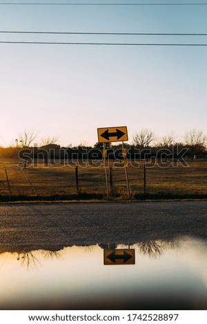 Beautiful golden hour reflection and yellow two way sign in Buda Texas