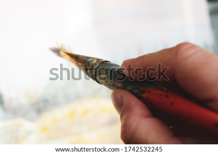 man holds a brush and paints a picture concept art