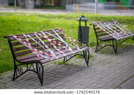 Park benches wrapped in connection with the coronavirus pandemic. social distance, forbidden to sit down