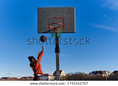 A pretty young blond woman playing basketball.                            