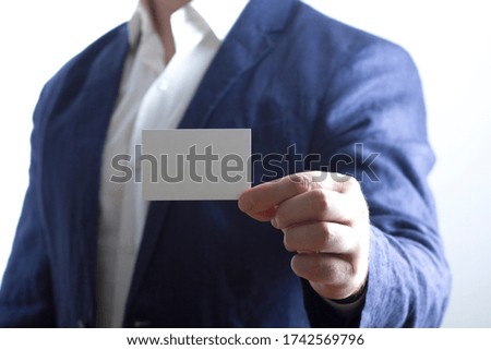 Hand holding white business card on white background
