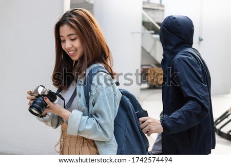 Pickpocket thief stealing wallet from backpack of tourist Asian girl Royalty-Free Stock Photo #1742574494