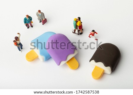 close up of some miniature people near miniature ice cream