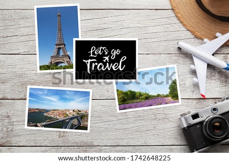 Travel concept with vacation photos, airplane toy, camera and sun hat on wooden table. Top view flat lay with copy space