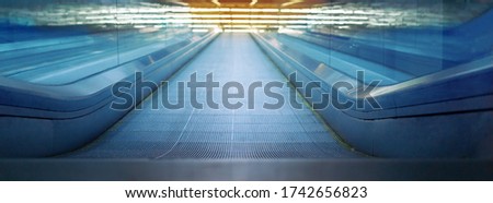 Close-up of modern blue metal escalator under bright yellow neon light. Concept of up motion, banner design. Part of airport terminal building and convenient escalator Royalty-Free Stock Photo #1742656823