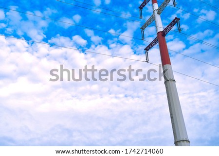 The electricity transmission tower and wires against the blue sky
