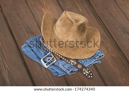 Cowboy hat and accessories over  wood plank background with clipping path.