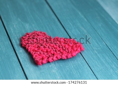  handmade pink knitted heart shape on blue wooden boards , shabby chic valentine gift, shallow depth of field 
