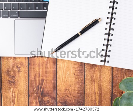 Flat lay, Office table wooden desk, Bright Creative workspace with labtop, green plant, pen, and notebook with the sunlight, Top view with copy space